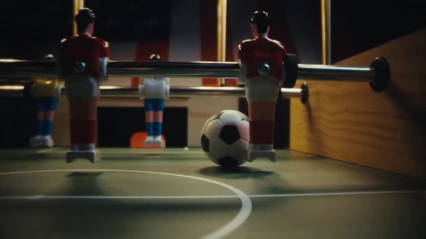 Plastic players on metal rods and a ball on the foosball table