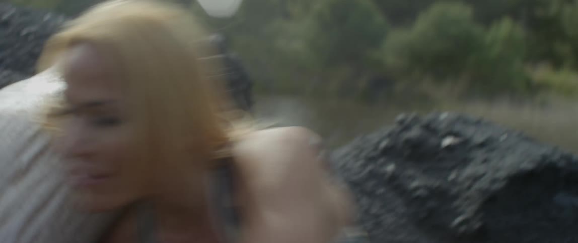 A woman runs up a rocky hill and trips and falls