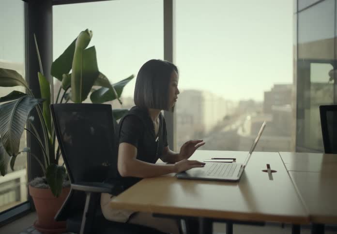 Woman working on a laptop in an office room in a building