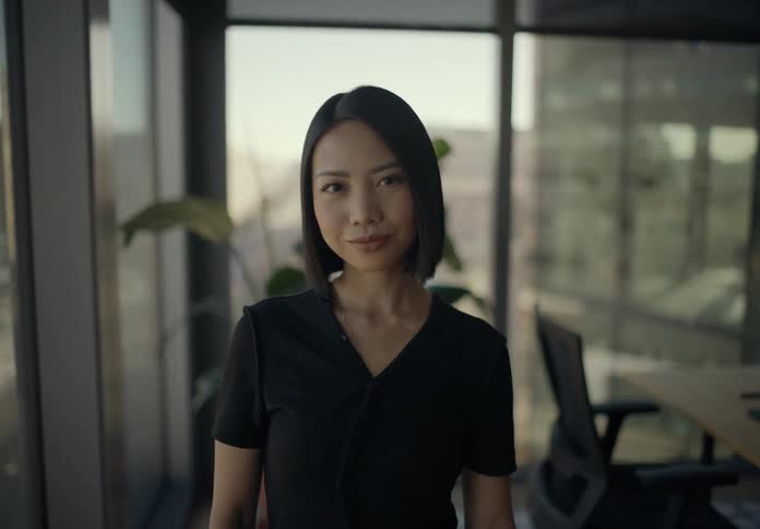 Woman holding a smartphone in an office room