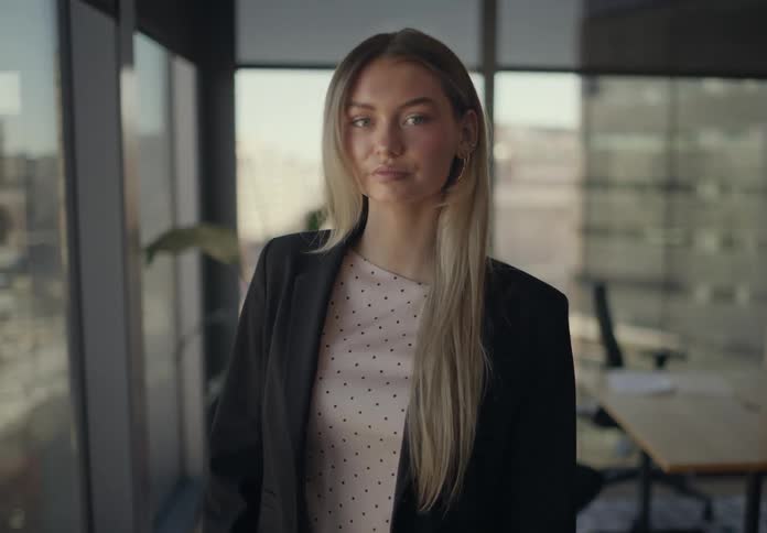 Blonde woman in a black blazer in an office room