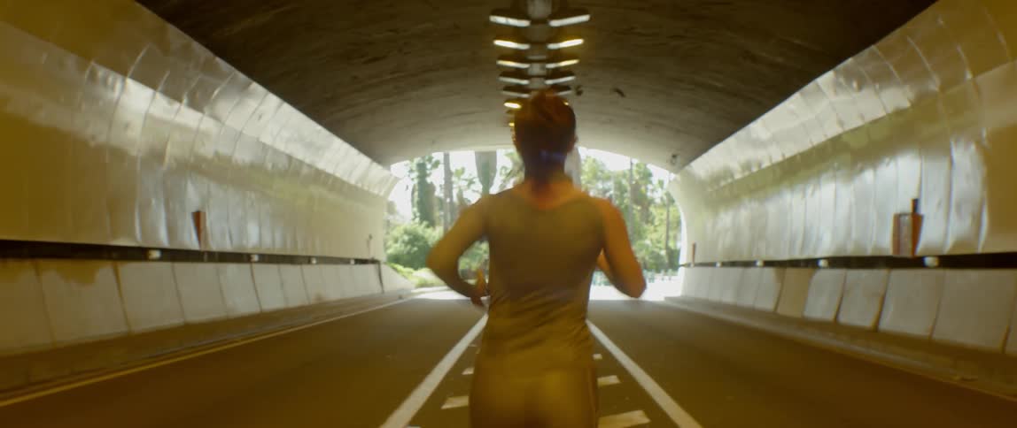 Woman jogging through tunnel