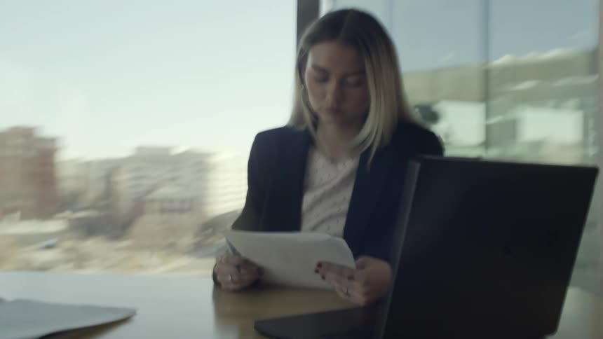 A woman at a desk looking at paperwork