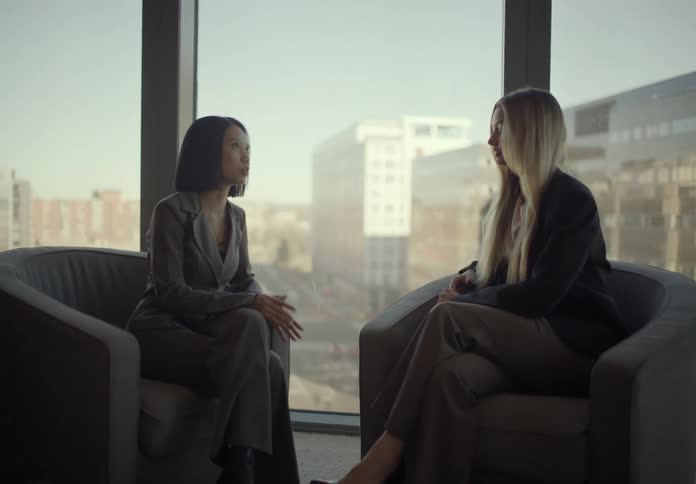 Two women sitting and talking in an office setting