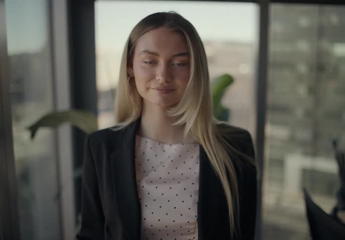 Blonde woman using a smartphone in an office room