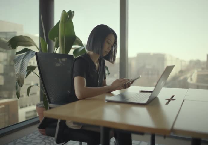 Woman typing on a laptop at an office desk