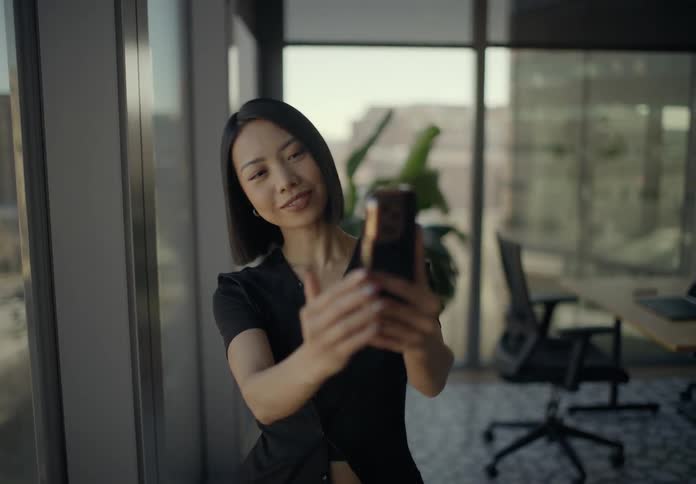 A woman records herself on her phone