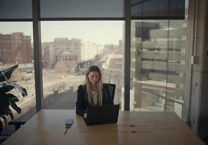 Woman working in front of a laptop in an office
