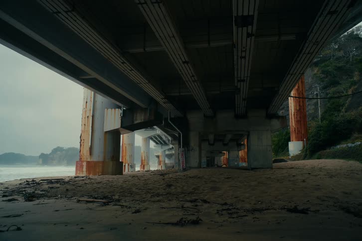 The video presents a static wide shot of a densely packed japanese residential neighborhood nestled against a backdrop of dark rolling hills under a twilight skythe scene is dominated by a mix of lowrise apartment buildings and traditional houses w