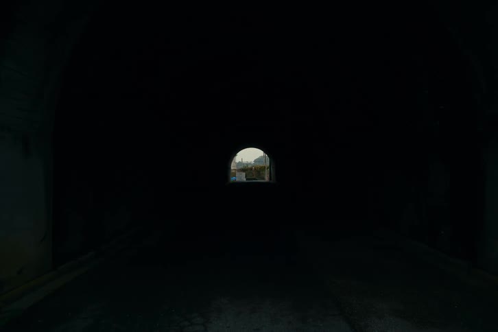 A view of a city from inside of a tunnel