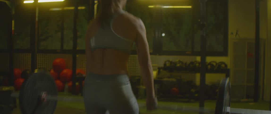 Ponytailed woman exercising with her barbell