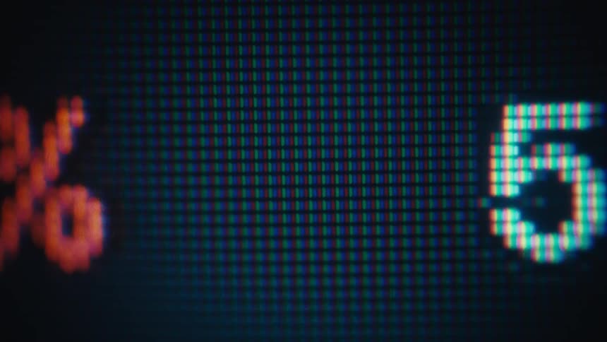 Close up of pixelated digital numbers and percentages scrolling across a screen