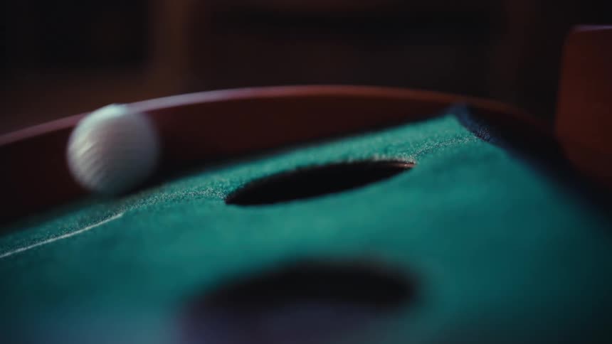 A golf ball rolling up a hill in a room
