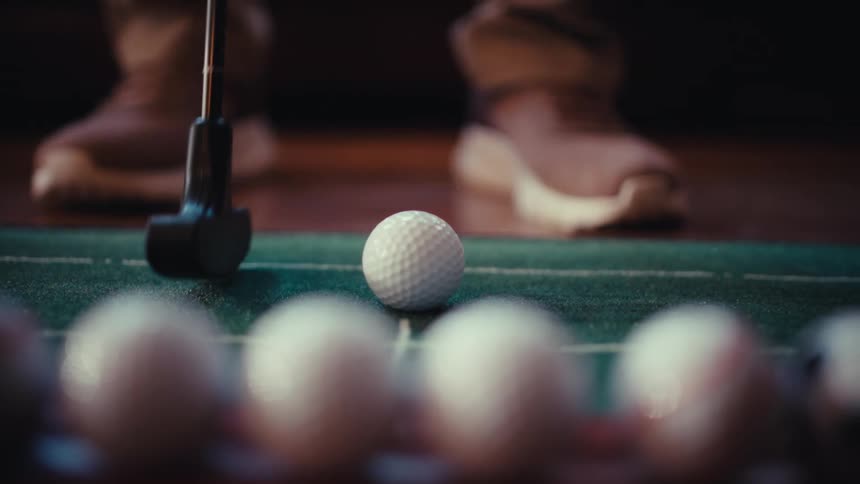 A person hitting a golf ball on a putting green