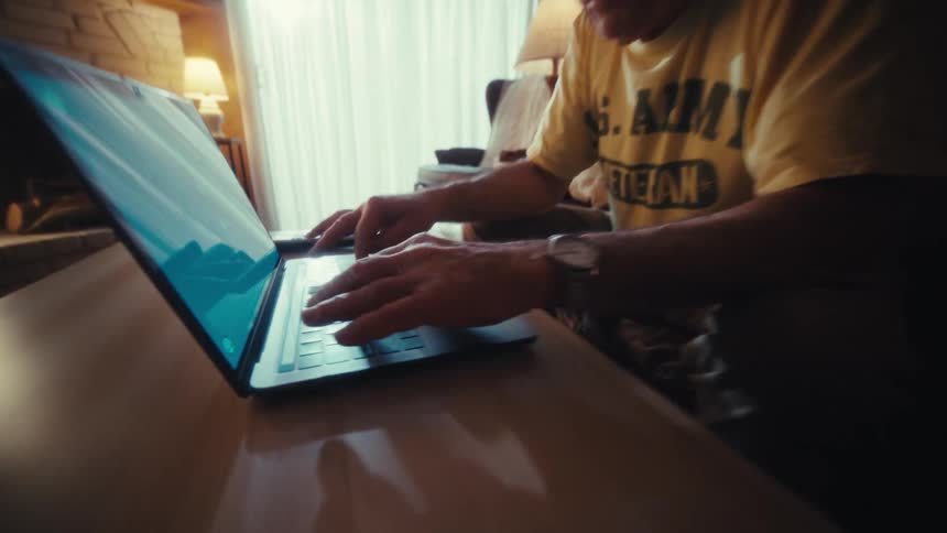 The man is typing fast on his laptop