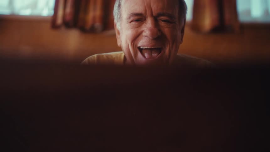 A man sitting in a room laughing