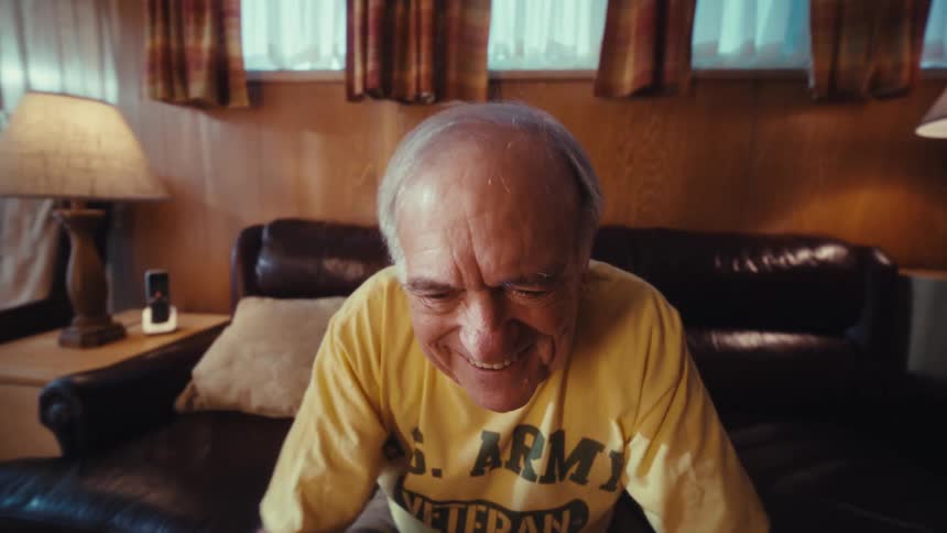 Smiling elderly man in front of a laptop