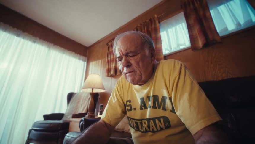 A man sitting in a room using a laptop