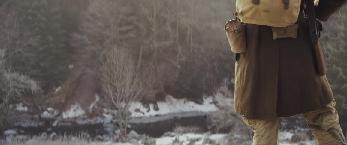 The hiker puts on his helmet by the stream