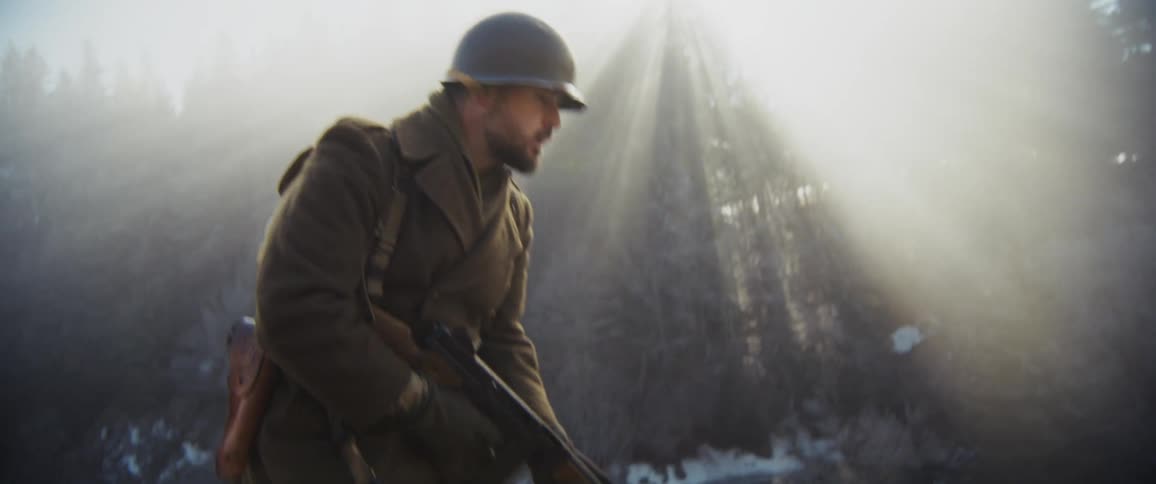 A soldier walking through a snowy forest
