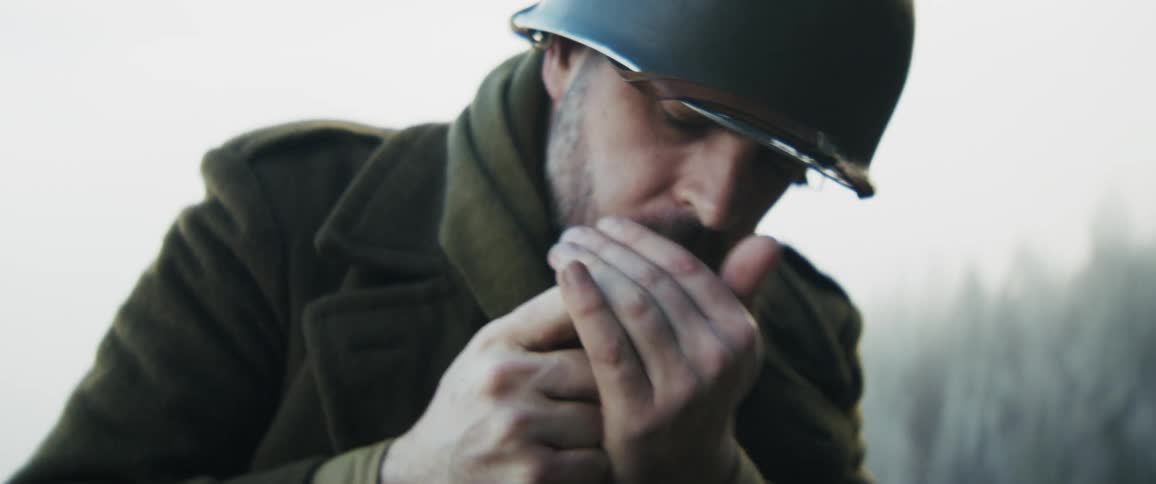 A soldier smoking a cigarette outdoors