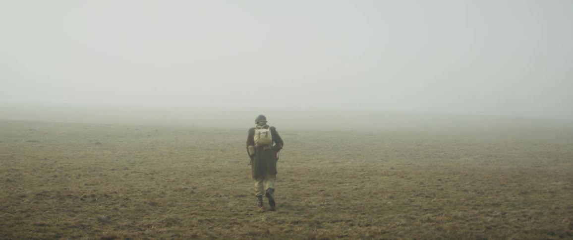 Soldier with a rifle walking through the fog
