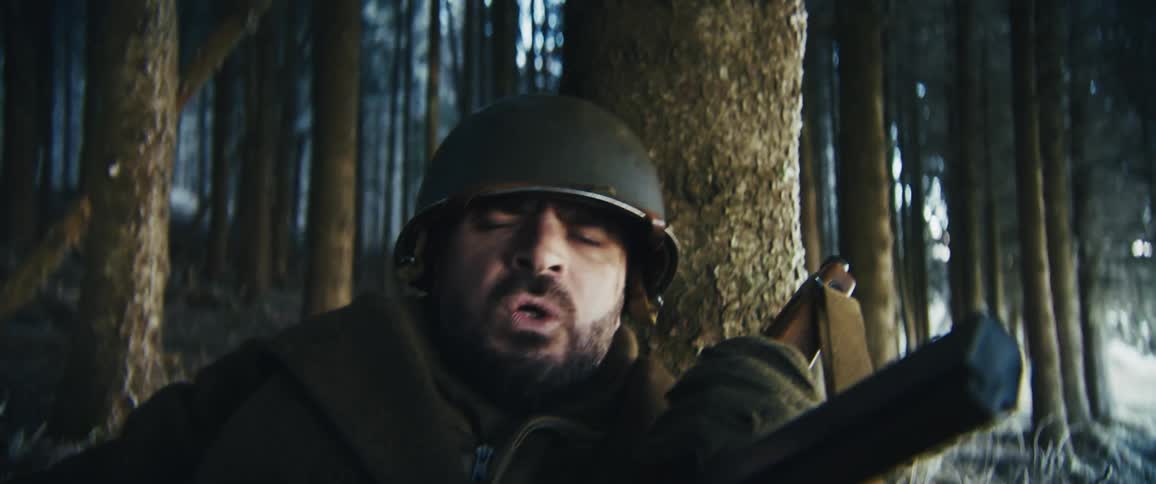 A soldier in the middle of a snow covered forest