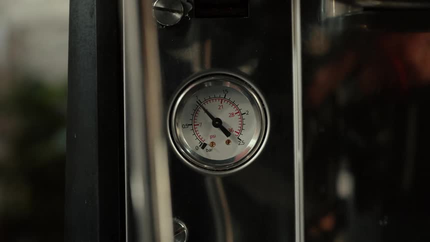 The gauge moves and steam rises on the machine