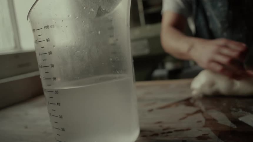 A person rolling out dough to make bread