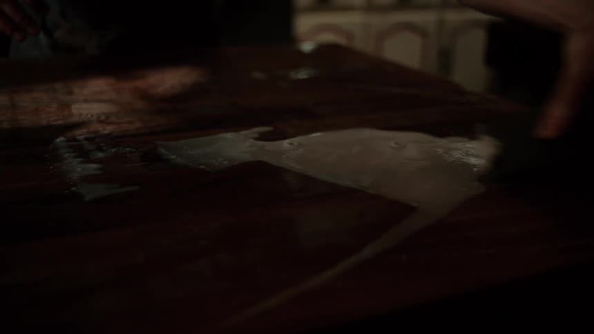 A person pushing dough and water on a counter