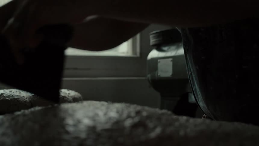 A chef molding dough by hand on a kitchen countertop beside a window at midday