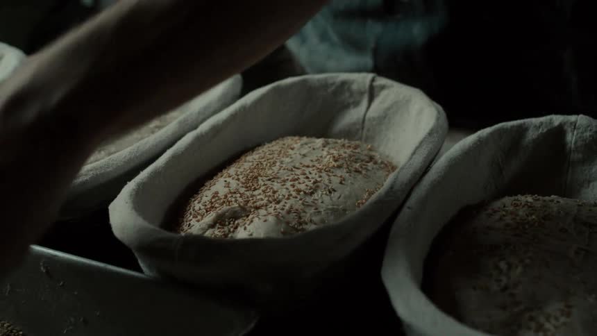 Seeds being sprinkled into bread dough