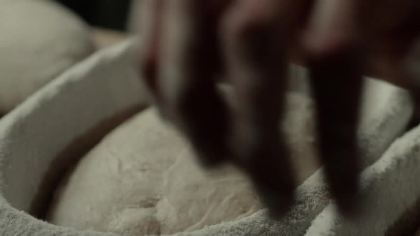 A person putting dough into a tray