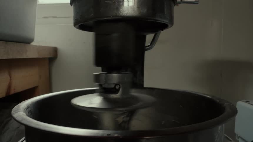 An electric mixer blending dough inside a bakery