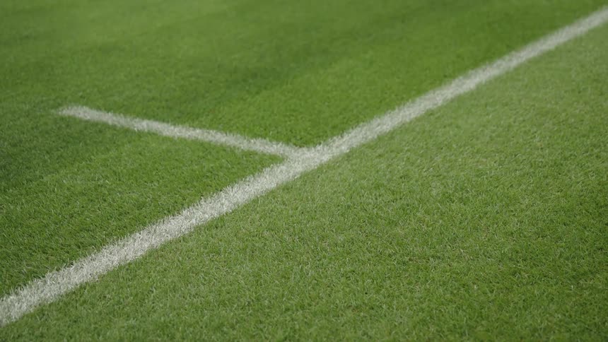 Closeup shot of white boundary lines on a vibrant green grass sports field