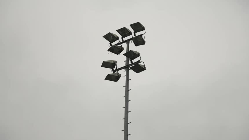 A tall lamp post is in the cloudy sky