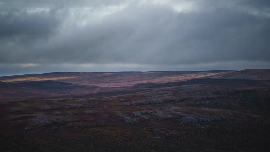 Rugged rolling mountains and highaltitude plains under a cloudy sky