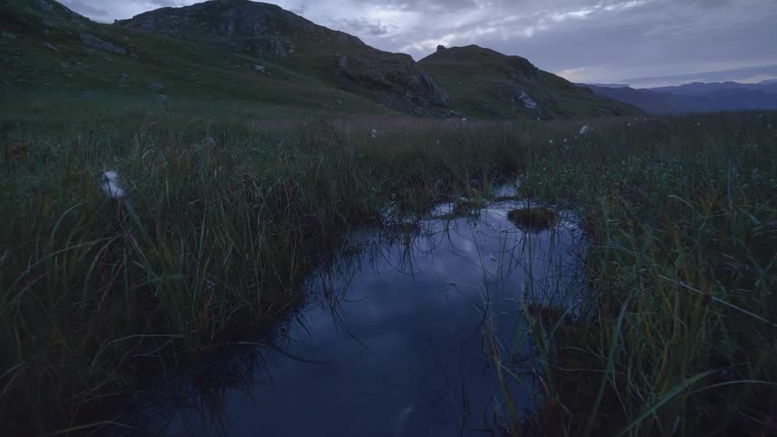 The small creek runs by the mountains