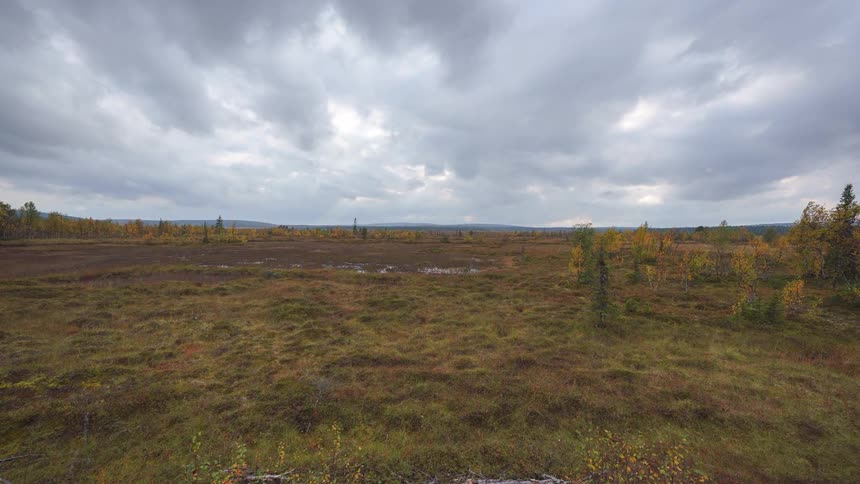 A timelapse scene shows a vast arctic tundra with autumn vegetation under a heavy moving cloud deck