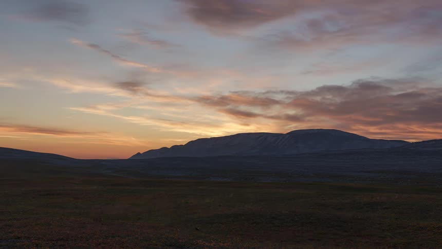 A timelapse of sun setting over a mountain