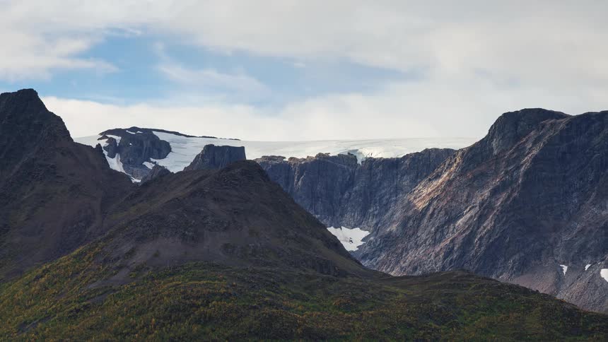 A view of a mountain range with clouds above it