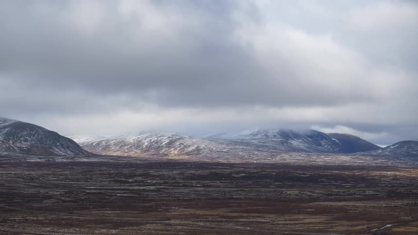 A view of a landscape with mountains covered in snow