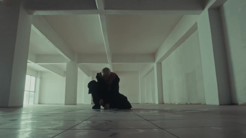 The man is dancing in the large room