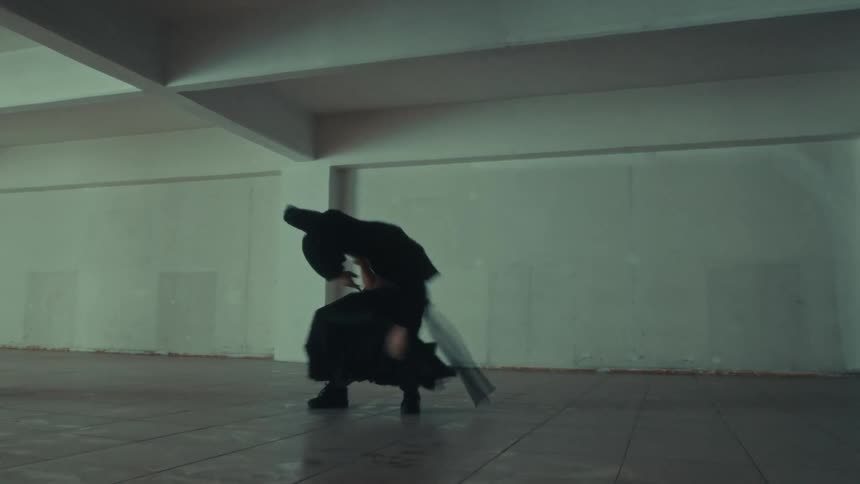 A young man in an underground parking lot showing off his dance moves