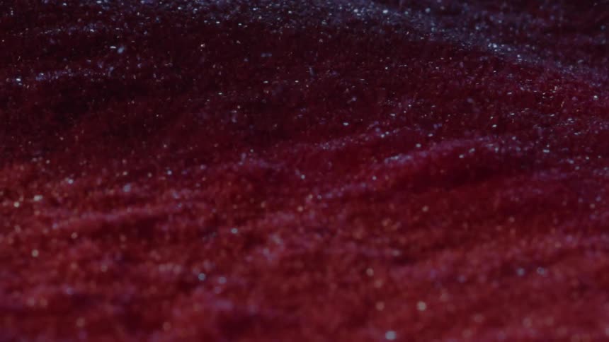 Red pigment in suspension forms a granular texture with shimmering particles