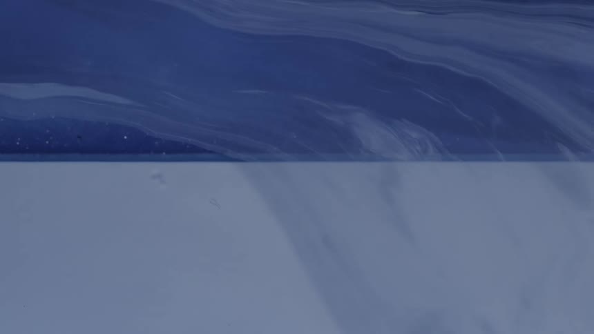 Thin layer of blue gray color flows over a surface divided into dark and pale