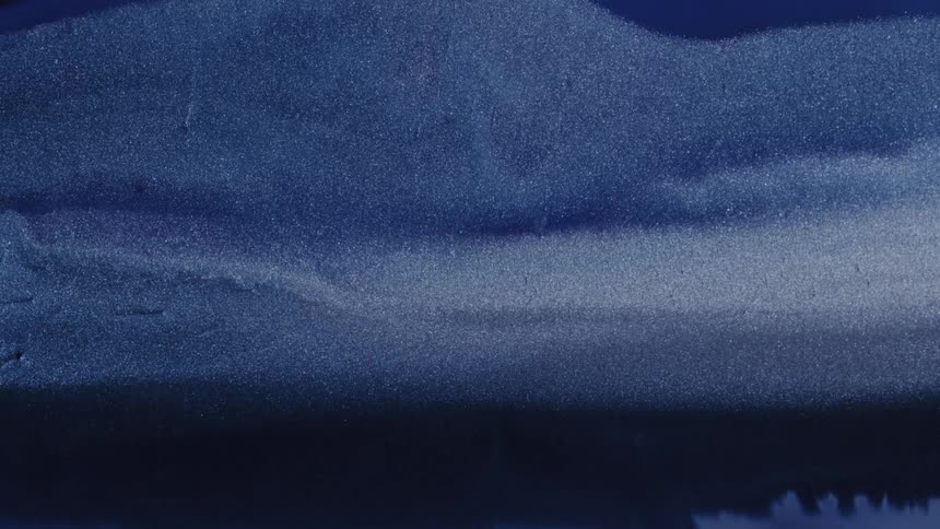 A brush stroke cutting through wet paint on a surface disrupting the natural flow pattern and creating a streak of shifted texture and direction