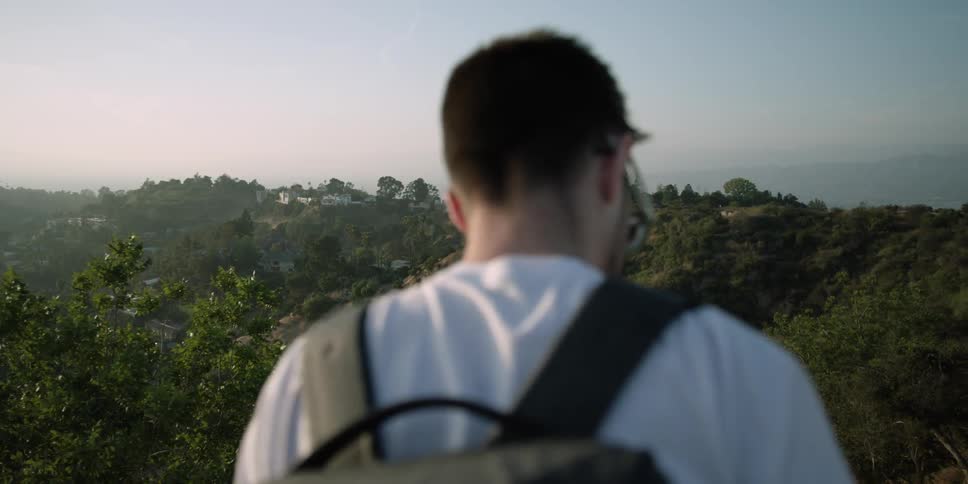 A man is standing on a hilltop