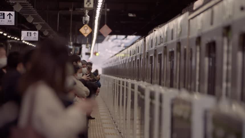 Train stopping at a station with a crowd of people