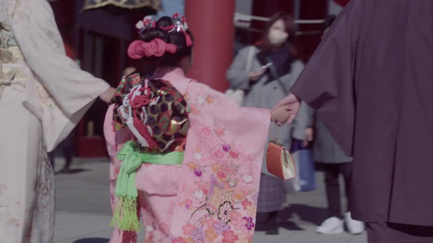 Family wearing a traditional japanese kimono walking through the city